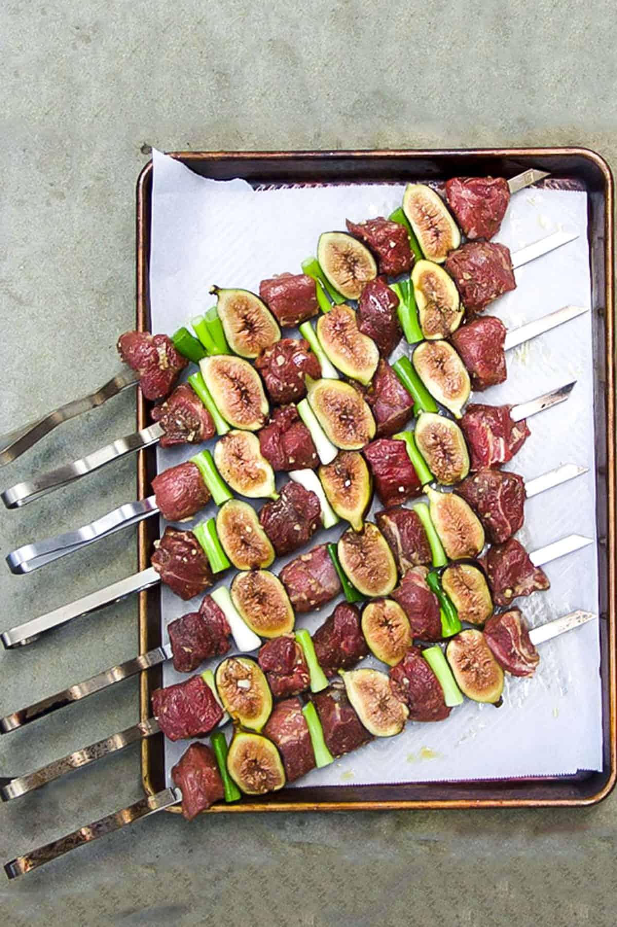 A close-up of the ingredients for the lamb kebabs laid out on a wooden board