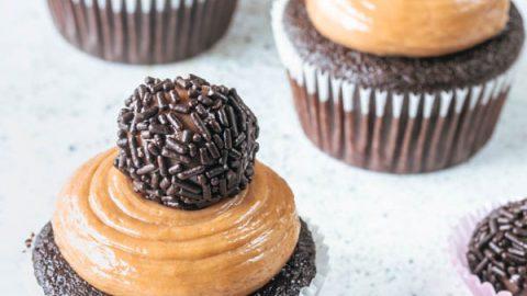 close up shot of brigadeiro frosting being piped onto a cupcake