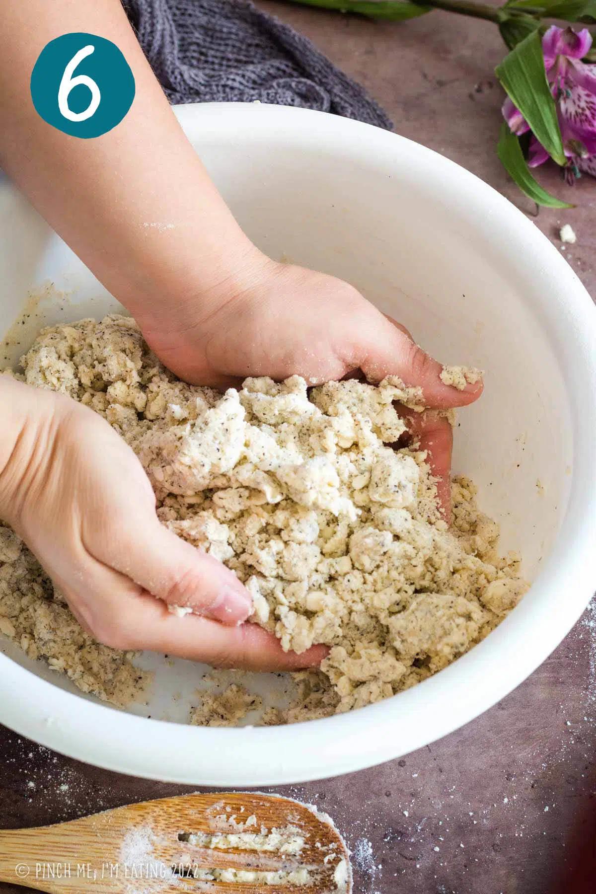 a baker adding lavender buds to a bowl of scone dough