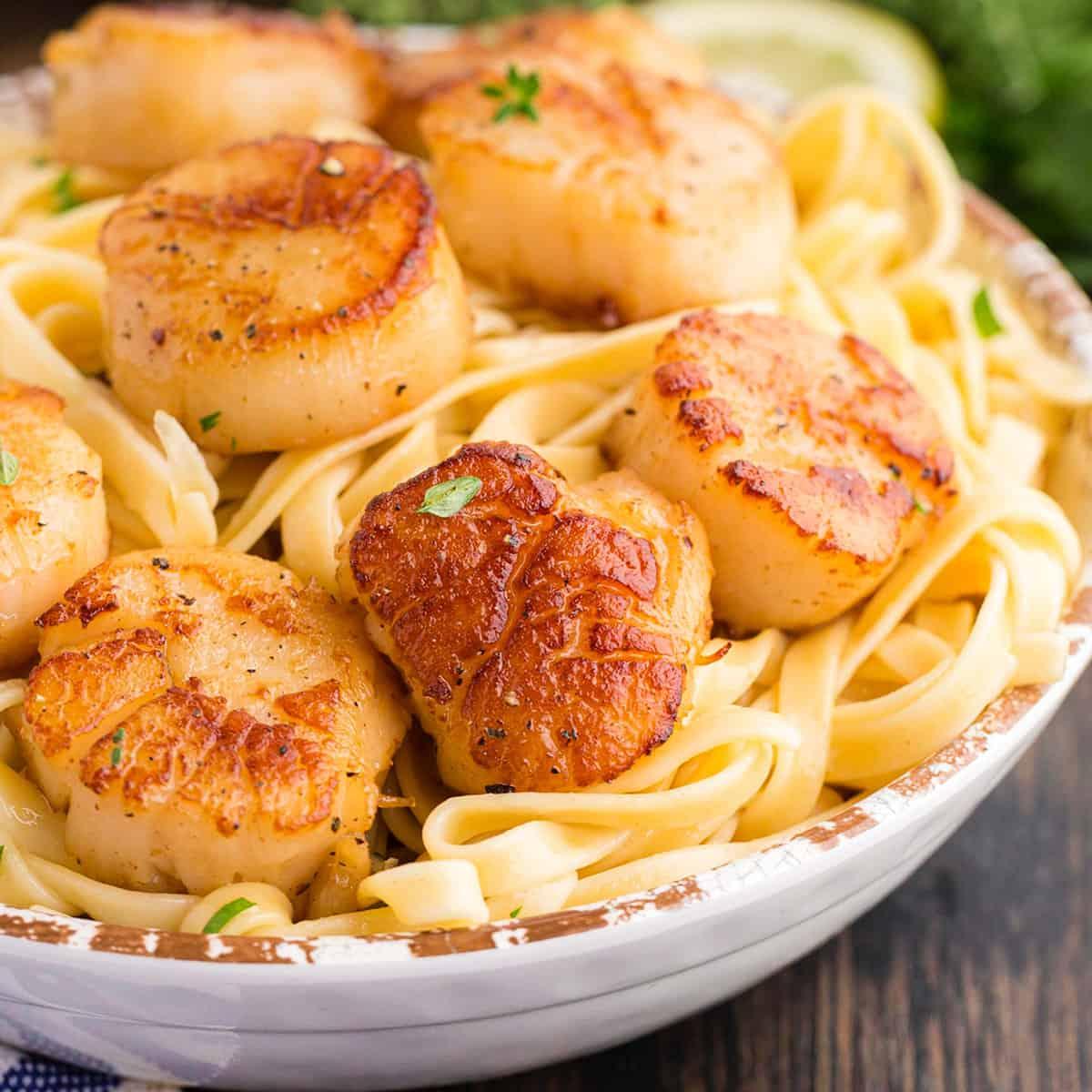 A table set for dinner, with a plate of sautéed scallops in the center