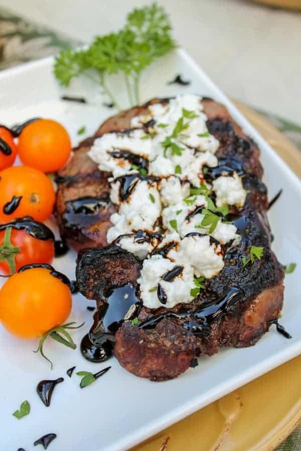 Close-up shot of balsamic glazed köttbullar with goat cheese, garnished with fresh herbs