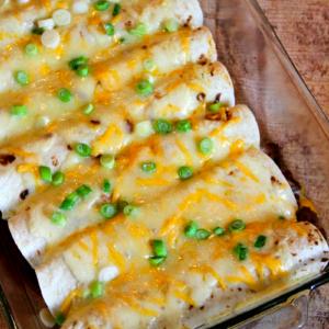 Overhead shot of a burrito casserole with various toppings like sour cream, salsa, and guacamole