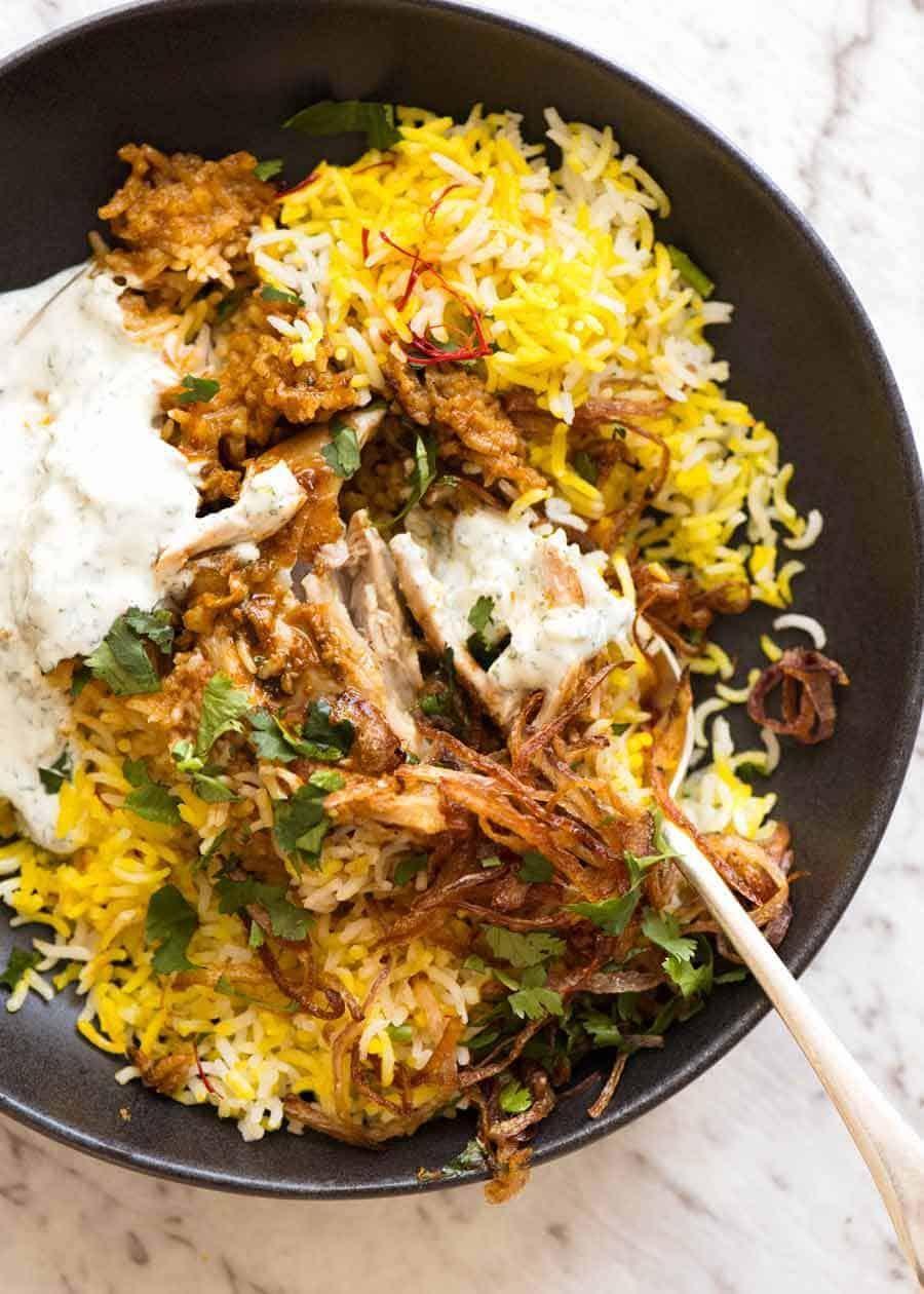 A vibrant, aromatic Spicy Cauliflower & Potato Biryani served in a rustic bowl, garnished with fresh cilantro and fried onions