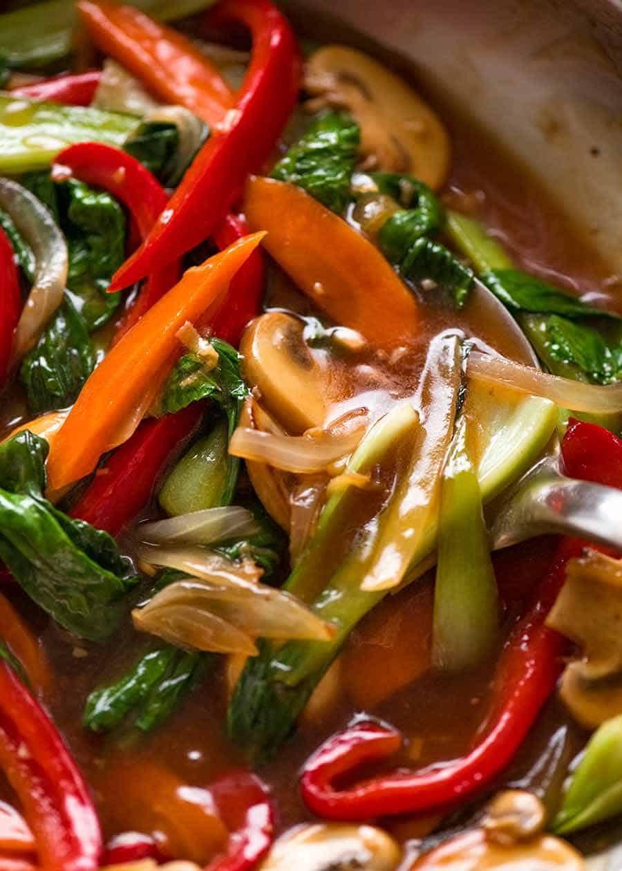 Close-up shot of a steaming bowl of China Vegetable Stir-Fry with Hoisin Sauce, garnished with chopped scallions