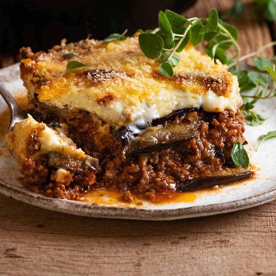 A golden-brown, appetizing moussaka, showing layers of eggplant, meat, and béchamel sauce