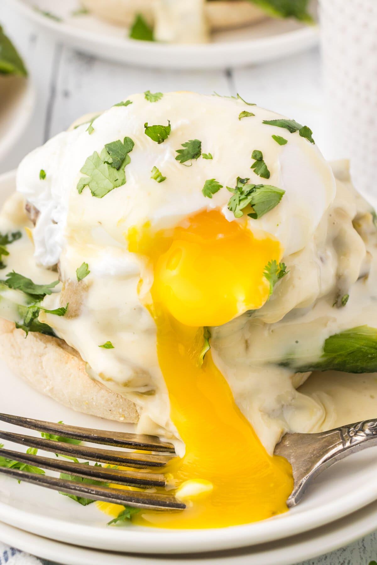 Close up shot of a person taking a bite out of a delicious Eggs Florentine Wrap.