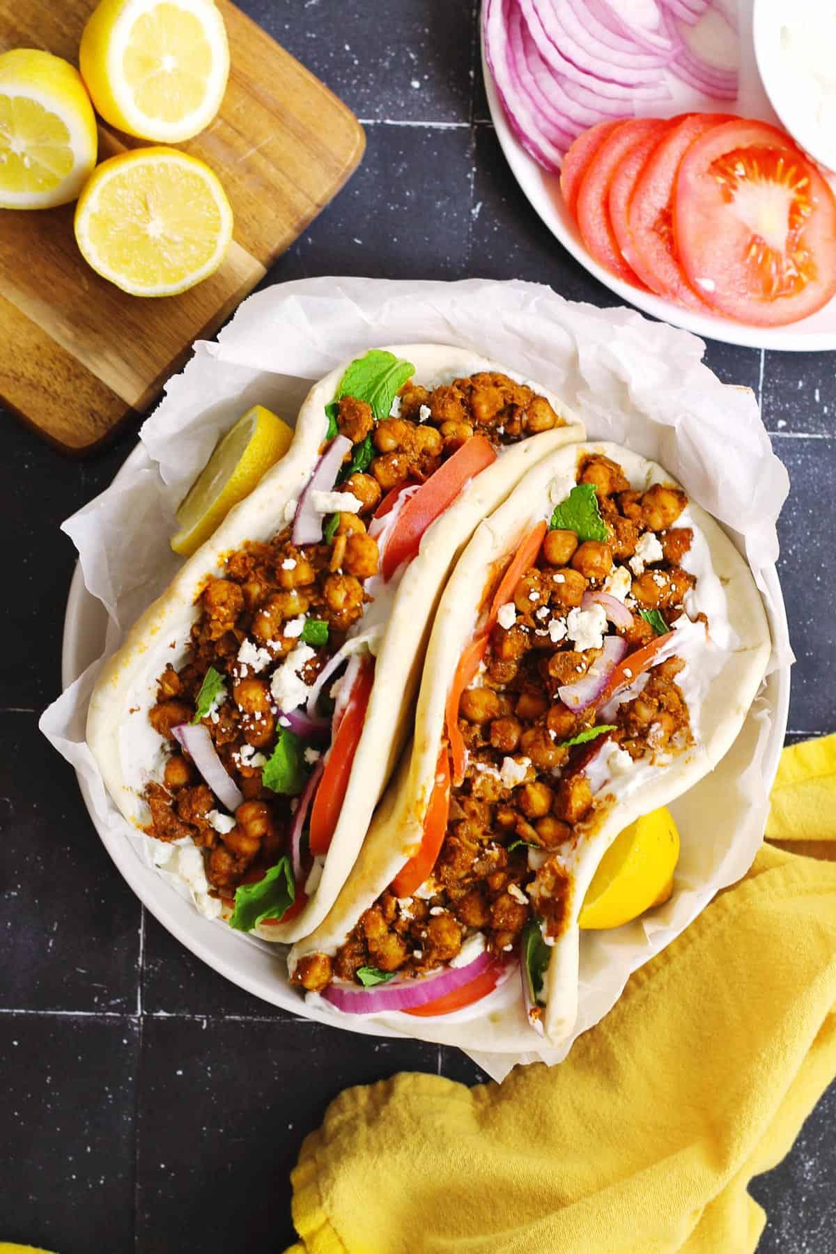 Assembled gyro with spiced chickpeas, gyro meat, and fresh vegetables