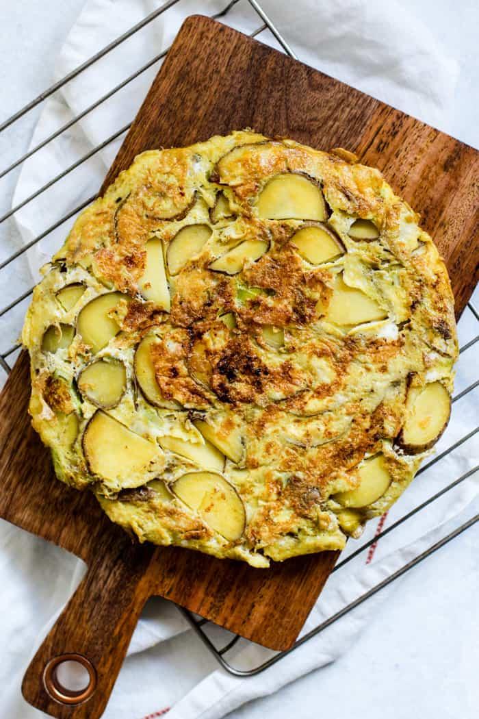 Close-up shot of a perfectly cooked Tortilla Española, showing the layers of potatoes and onions