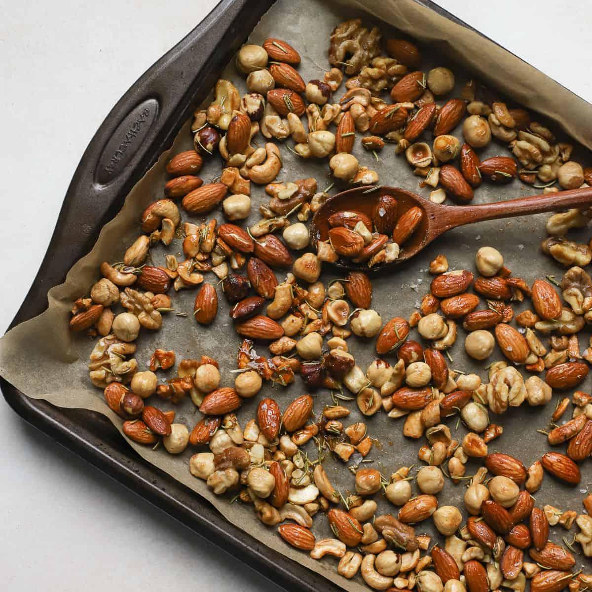 a person reaching for a handful of lemon herb toasted walnuts