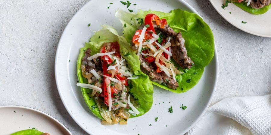 Person enjoying a Philly cheesesteak lettuce wrap
