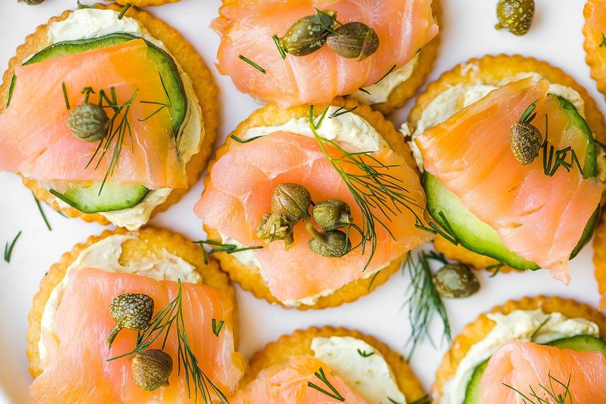 close-up shot of smoked salmon on a cracker, garnished with dill