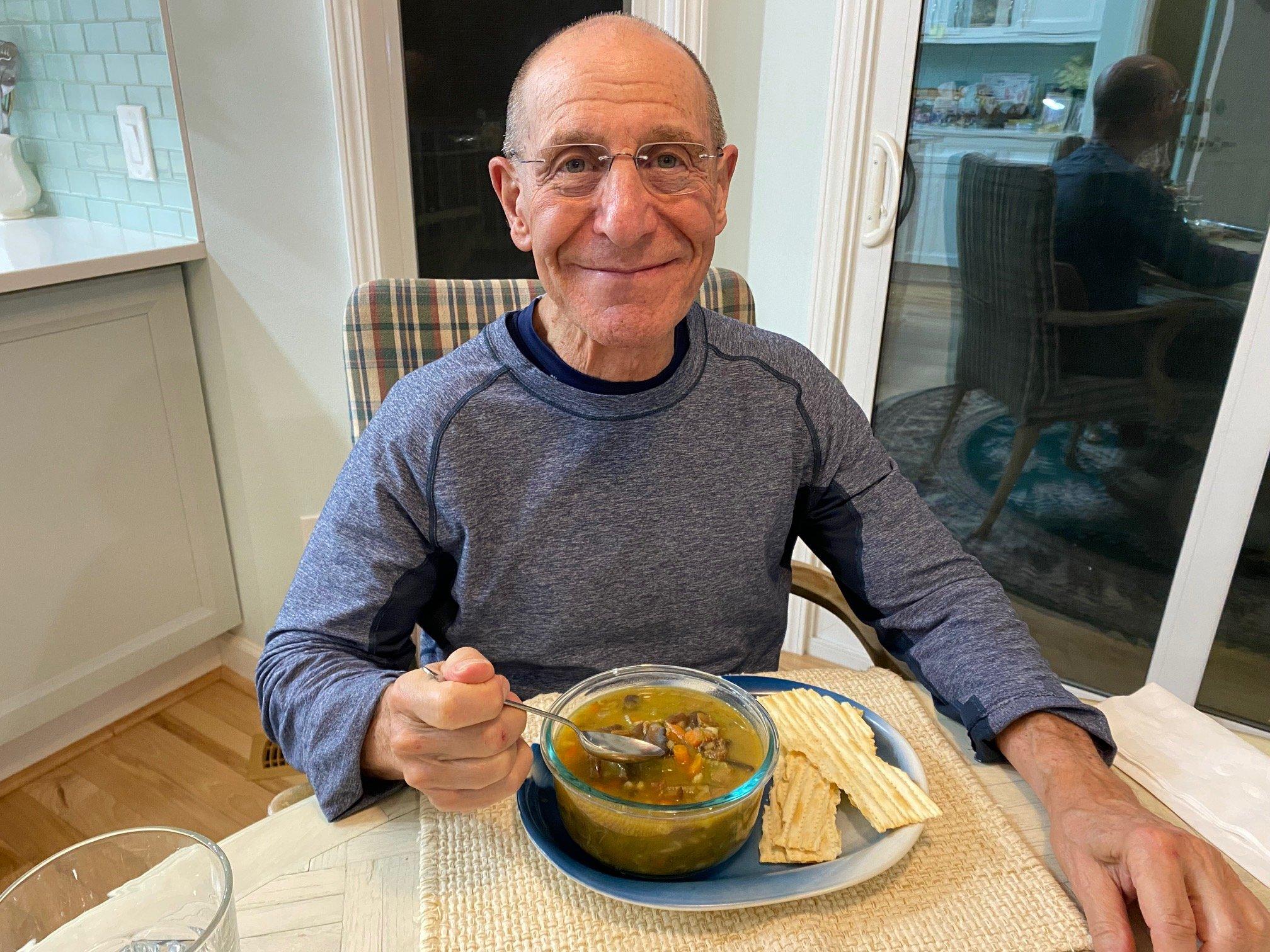 A person serving a bowl of barley and mushroom ragout