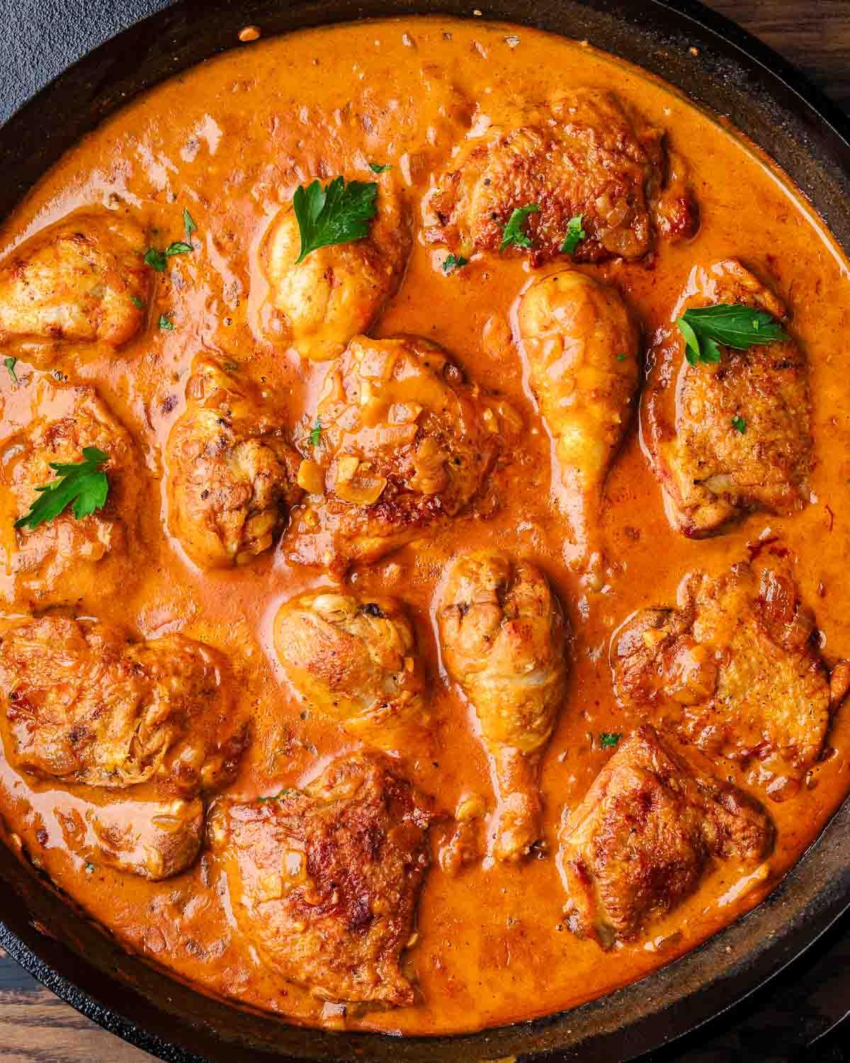 A close-up of the chicken paprikash ingredients: chicken, paprika, caraway seeds, sour cream, onion, and garlic