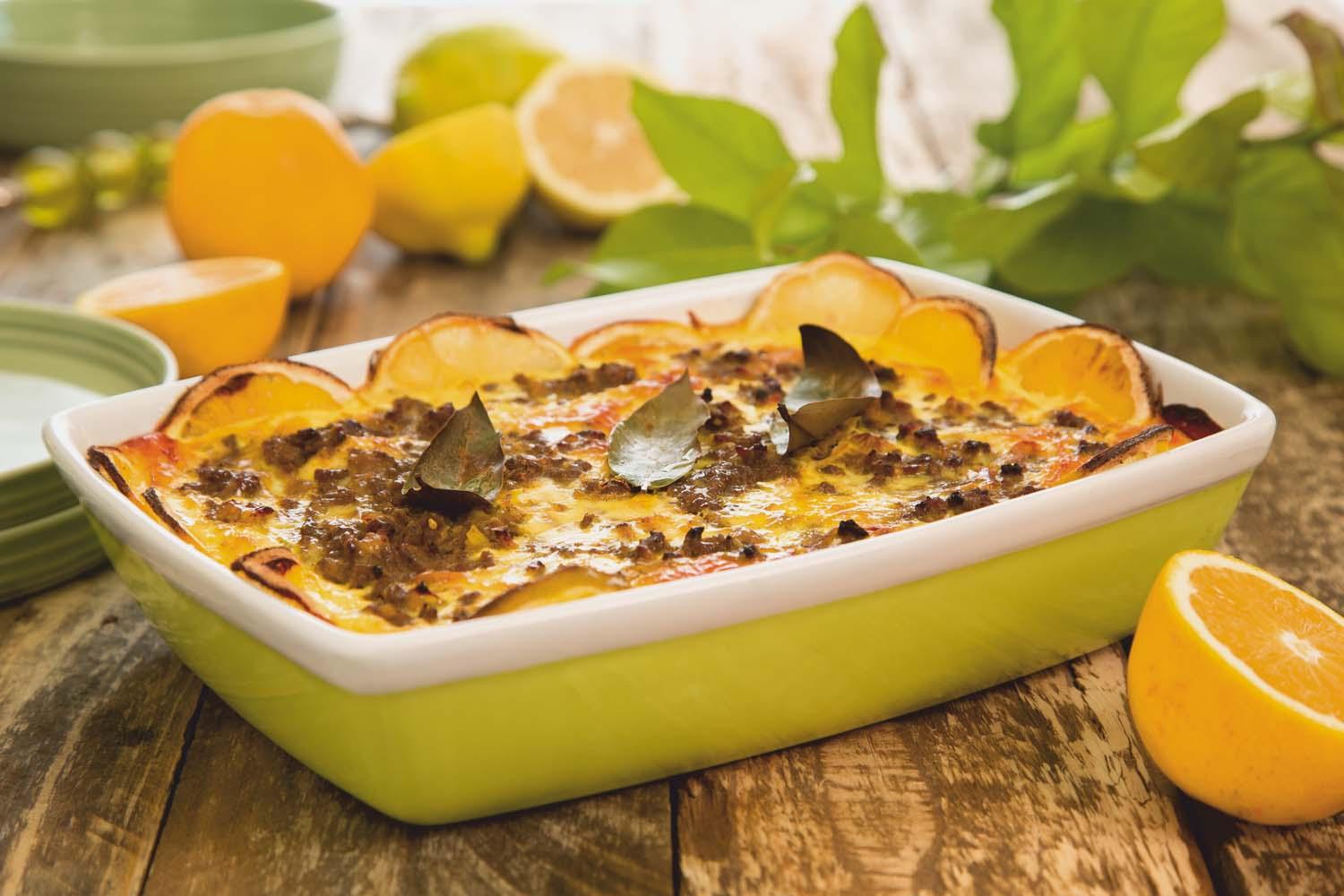 A beautifully presented Bobotie in a baking dish, garnished with fresh orange slices