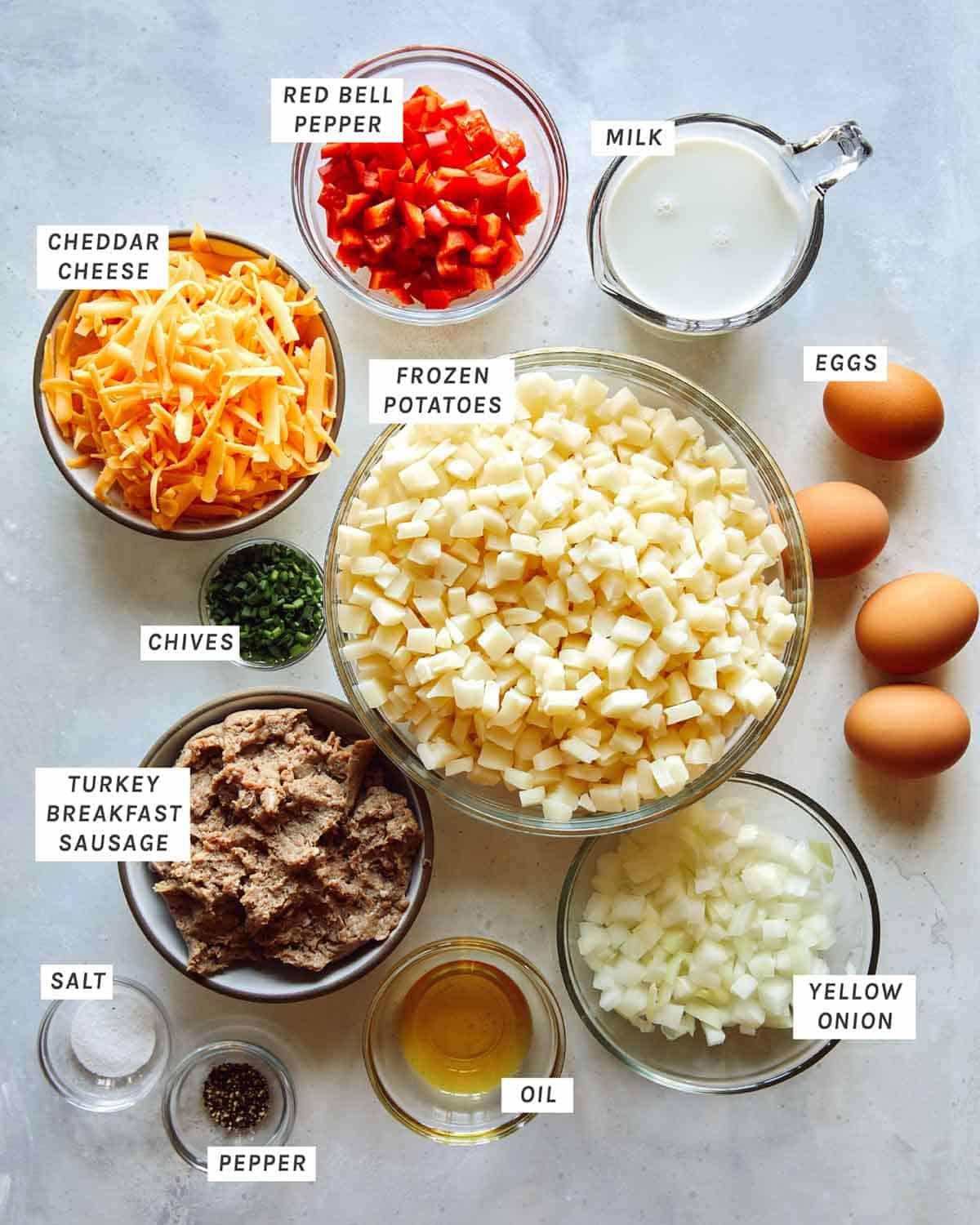 Ingredients for breakfast sausage and hash brown casserole laid out on a kitchen counter