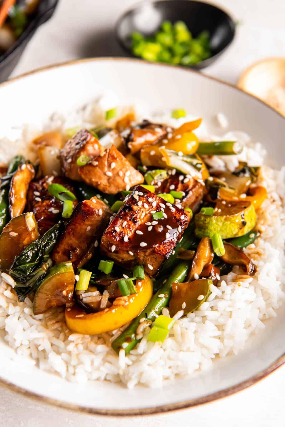 teriyaki glazed bell peppers on a plate garnished with sesame seeds and green onions
