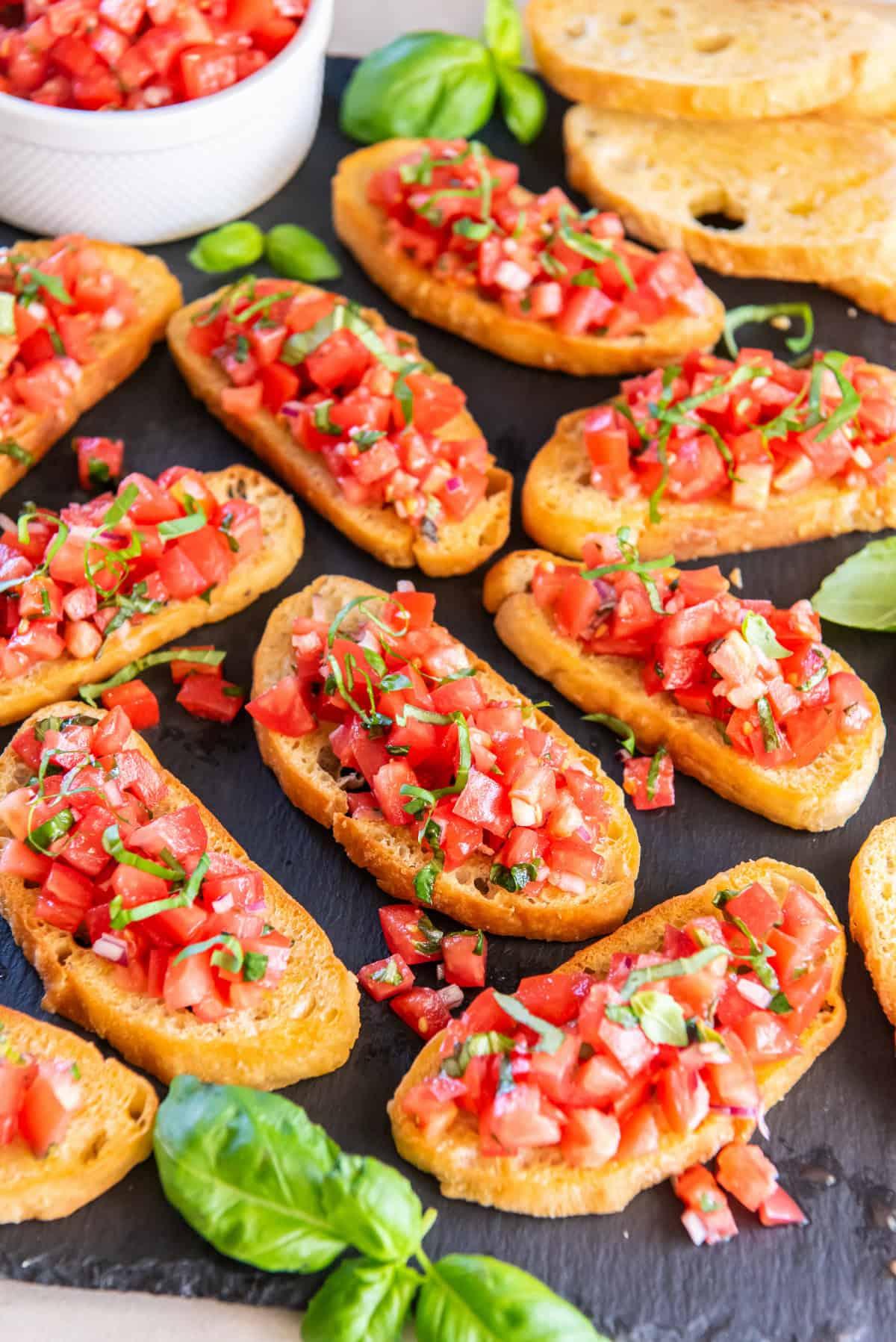 ingredients for grilled bread with tomato and basil arranged on a table