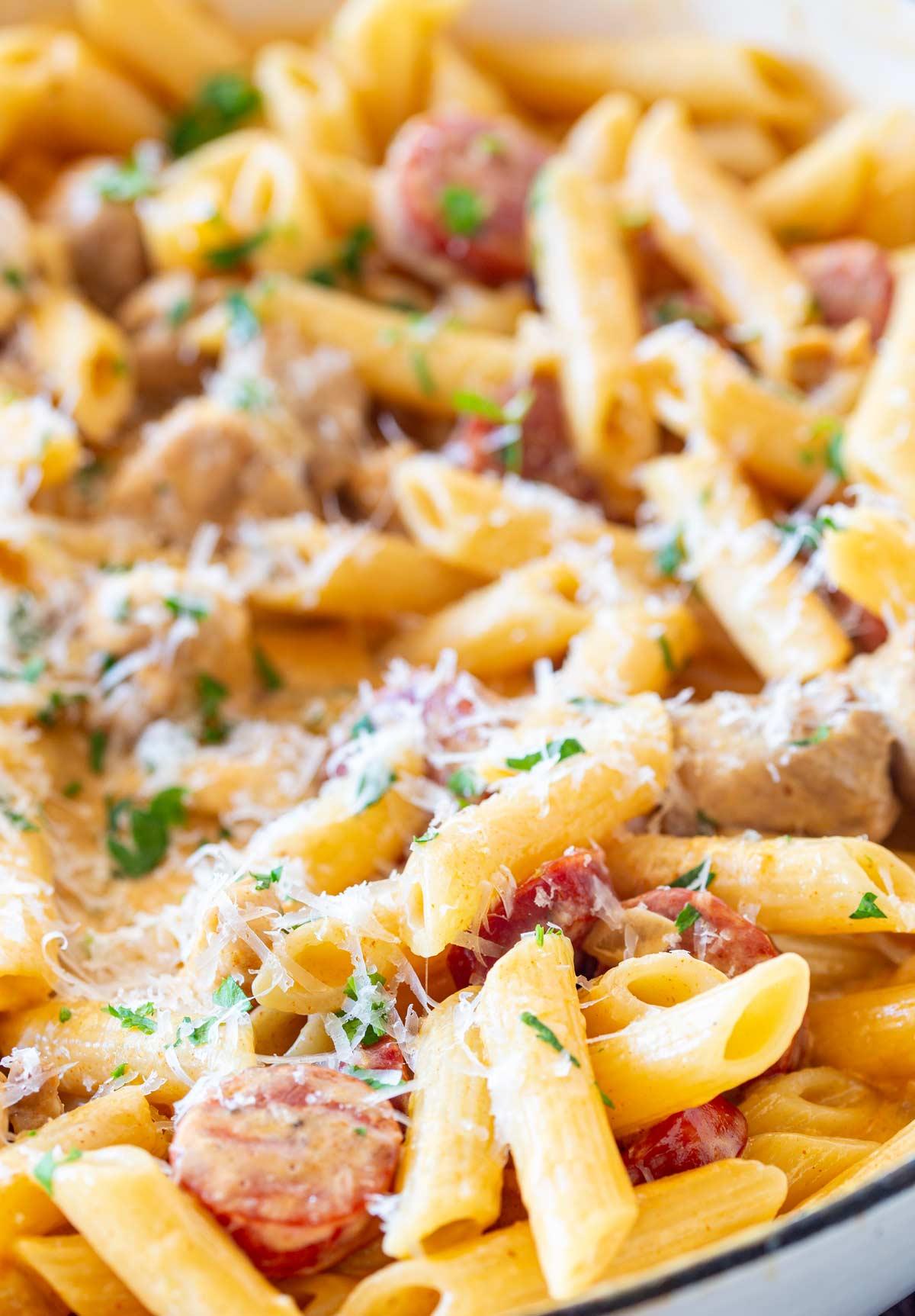 close-up shot of chicken and chorizo pasta with parmesan cheese sprinkled on top