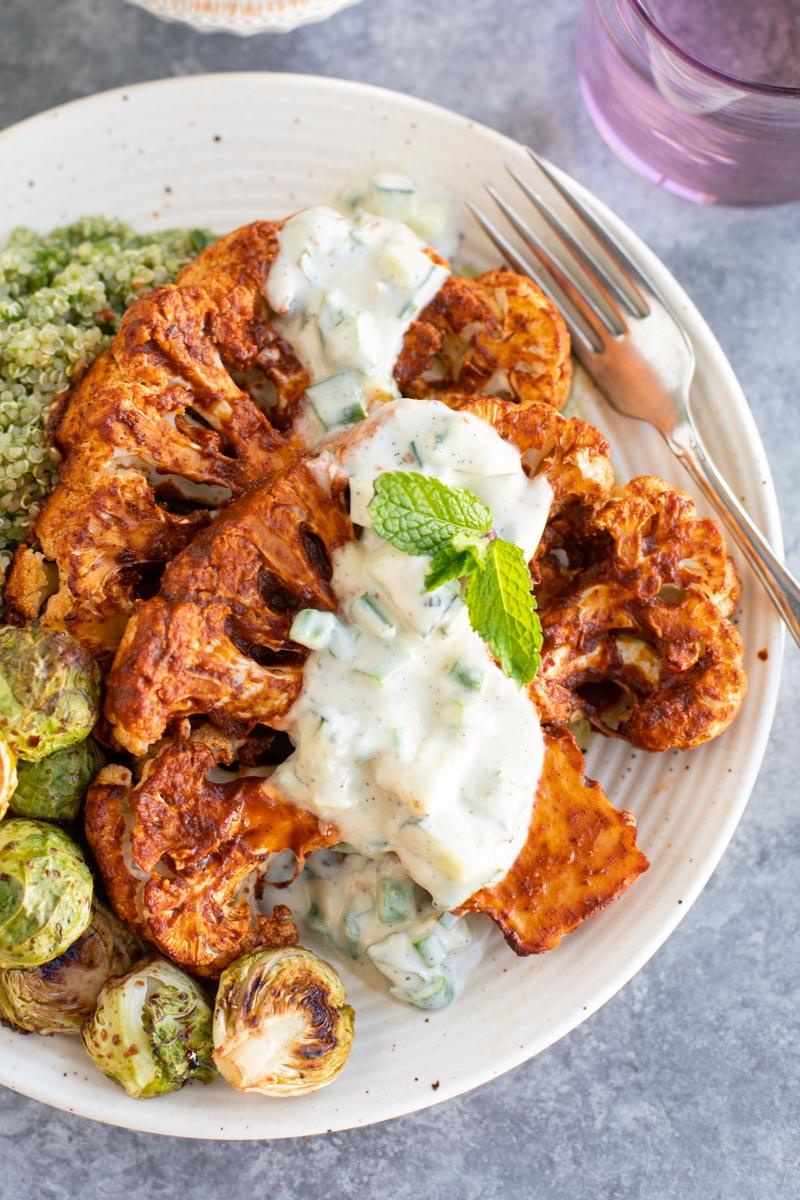 close-up shot of perfectly roasted cauliflower steaks served with a vibrant creamy tomato soup