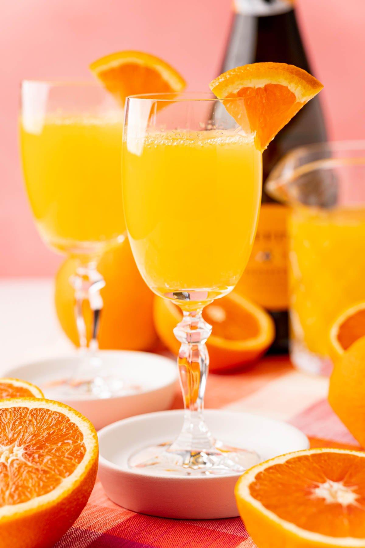 close-up of a mimosa smoothie being poured into a glass, garnished with an orange slice