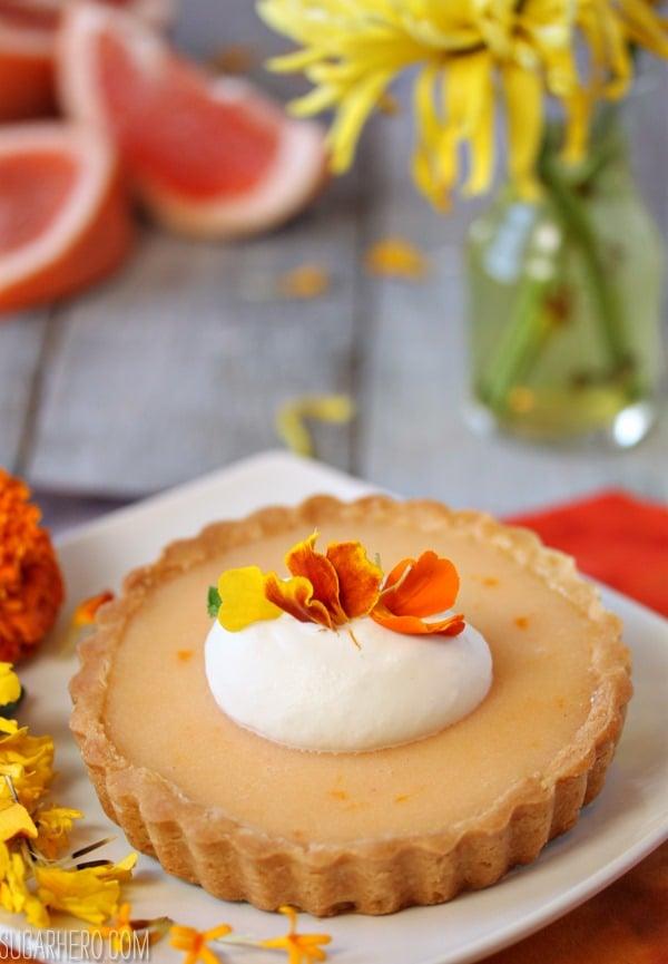 A beautifully styled grapefruit mint tart, garnished with fresh mint and powdered sugar