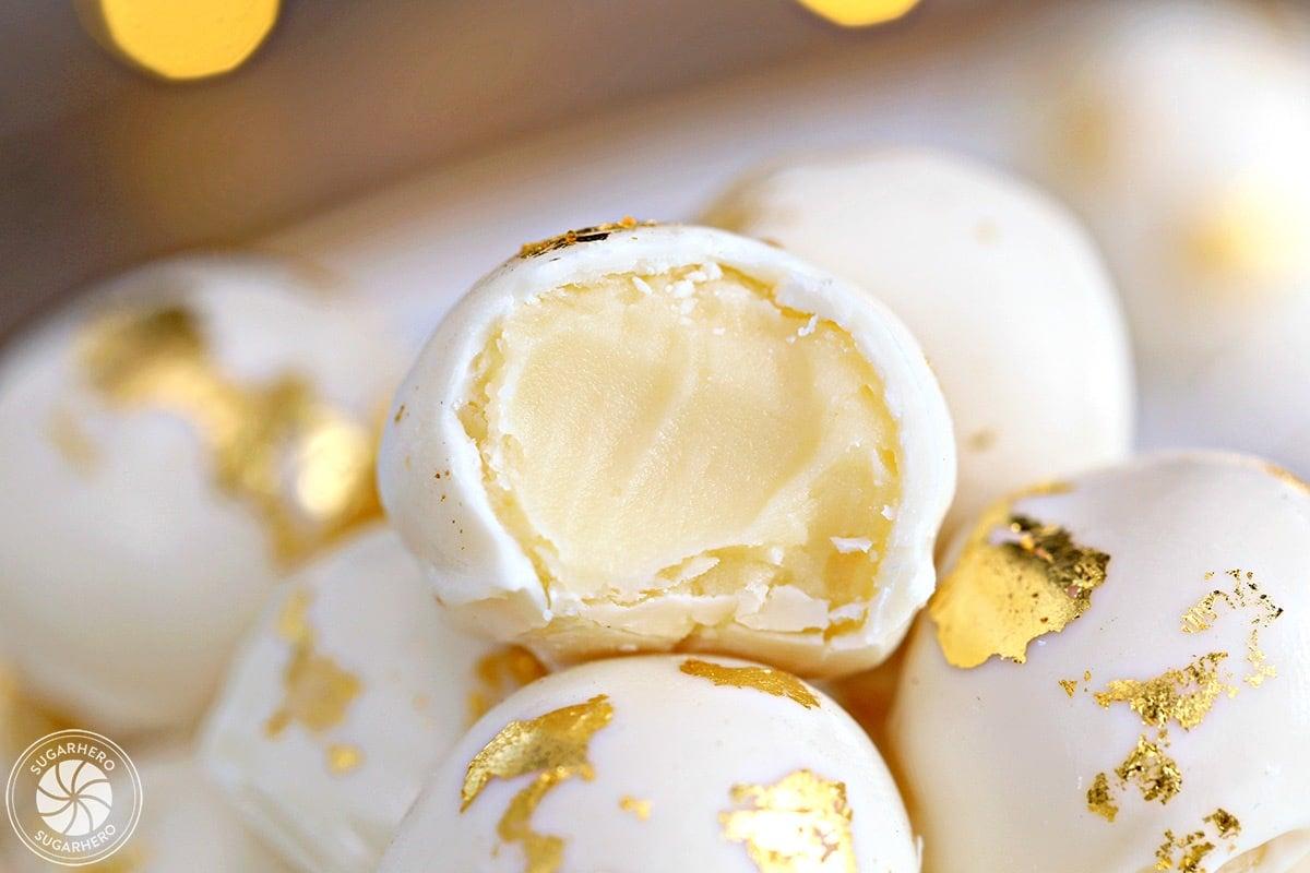close-up of a person taking a bite of a champagne truffle