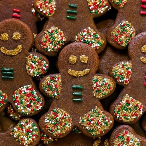 A plate of gingerbread men cookies decorated with icing and sprinkles