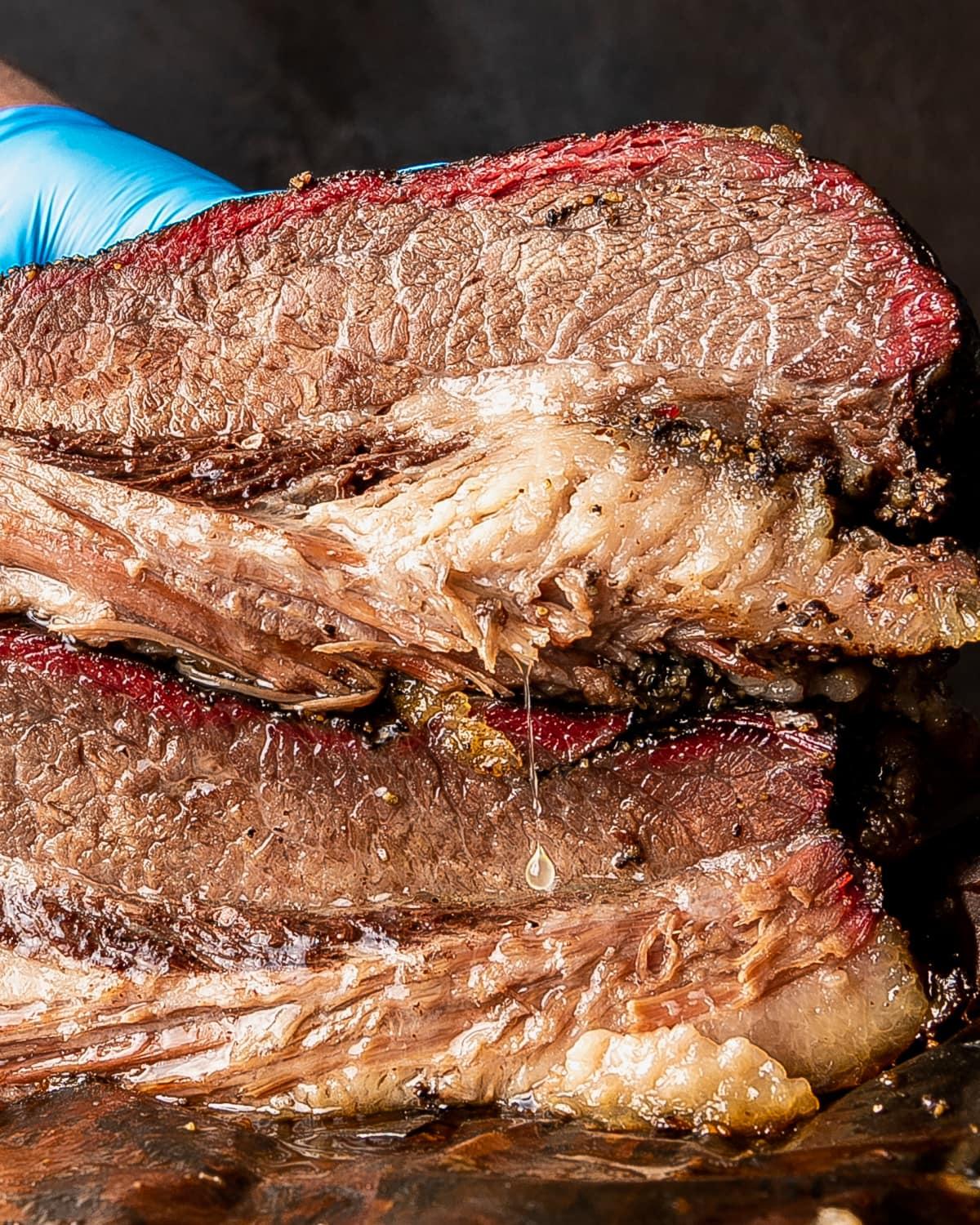 Close-up shot of a perfectly smoked brisket, glistening with smoke ring and tender meat.