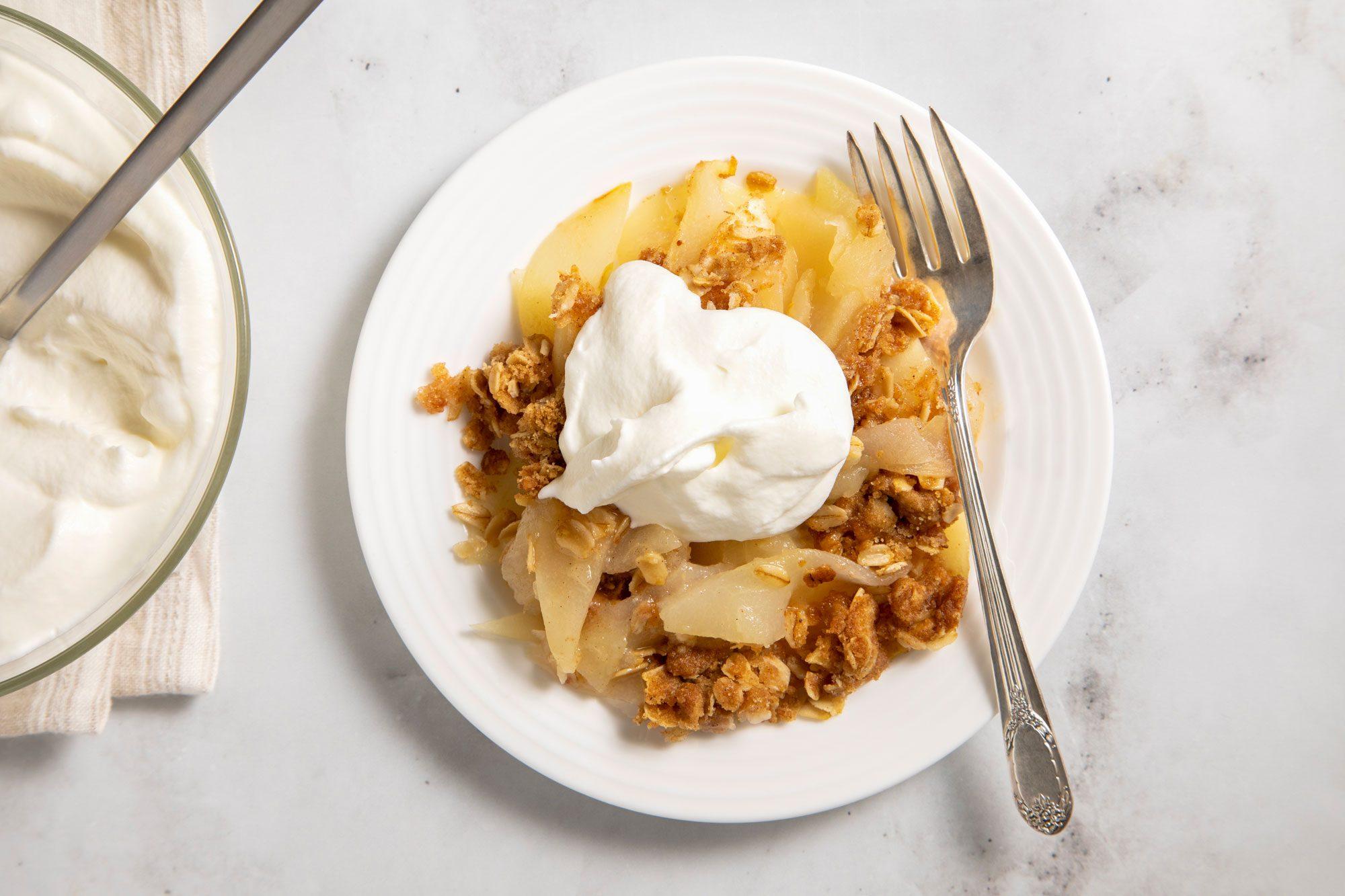 a slice of apple and pear crisp being served with vanilla ice cream
