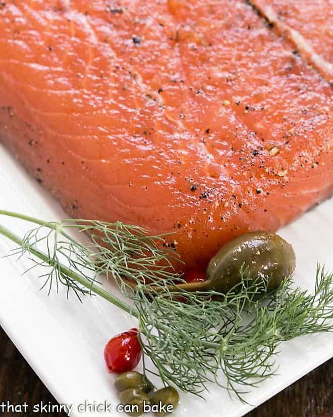 Close-up of gravlax with peach and rosemary, garnished with fresh herbs