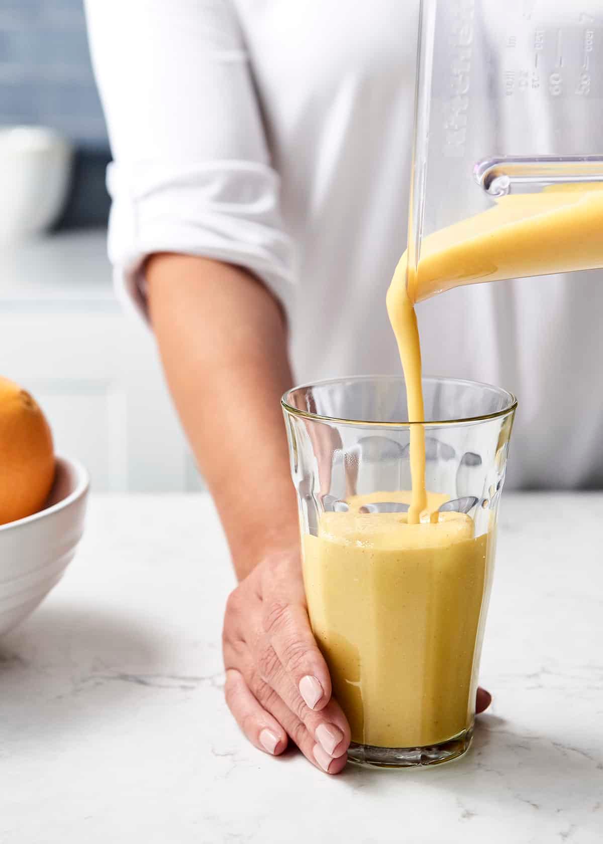 Close-up shot of a person enjoying an orange creamsicle smoothie