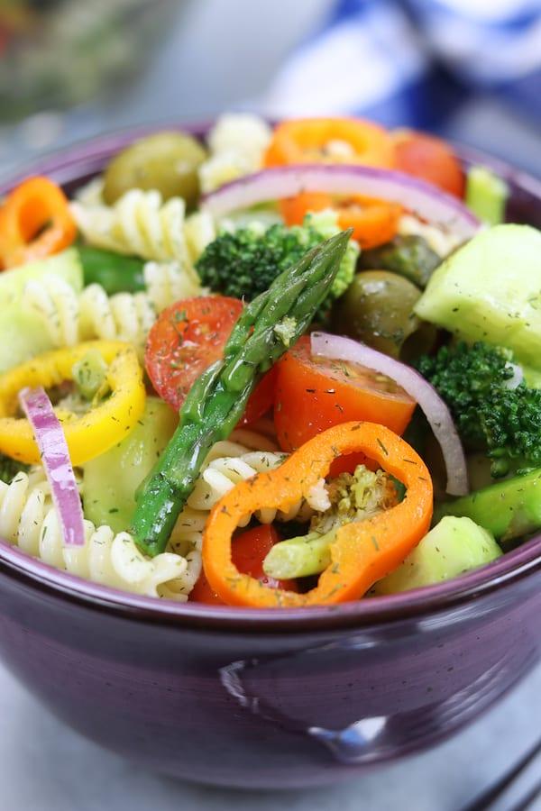 Close-up shot of a bowl of Springtime Garden Pasta Salad, showing the vibrant colors of the vegetables and herbs.
