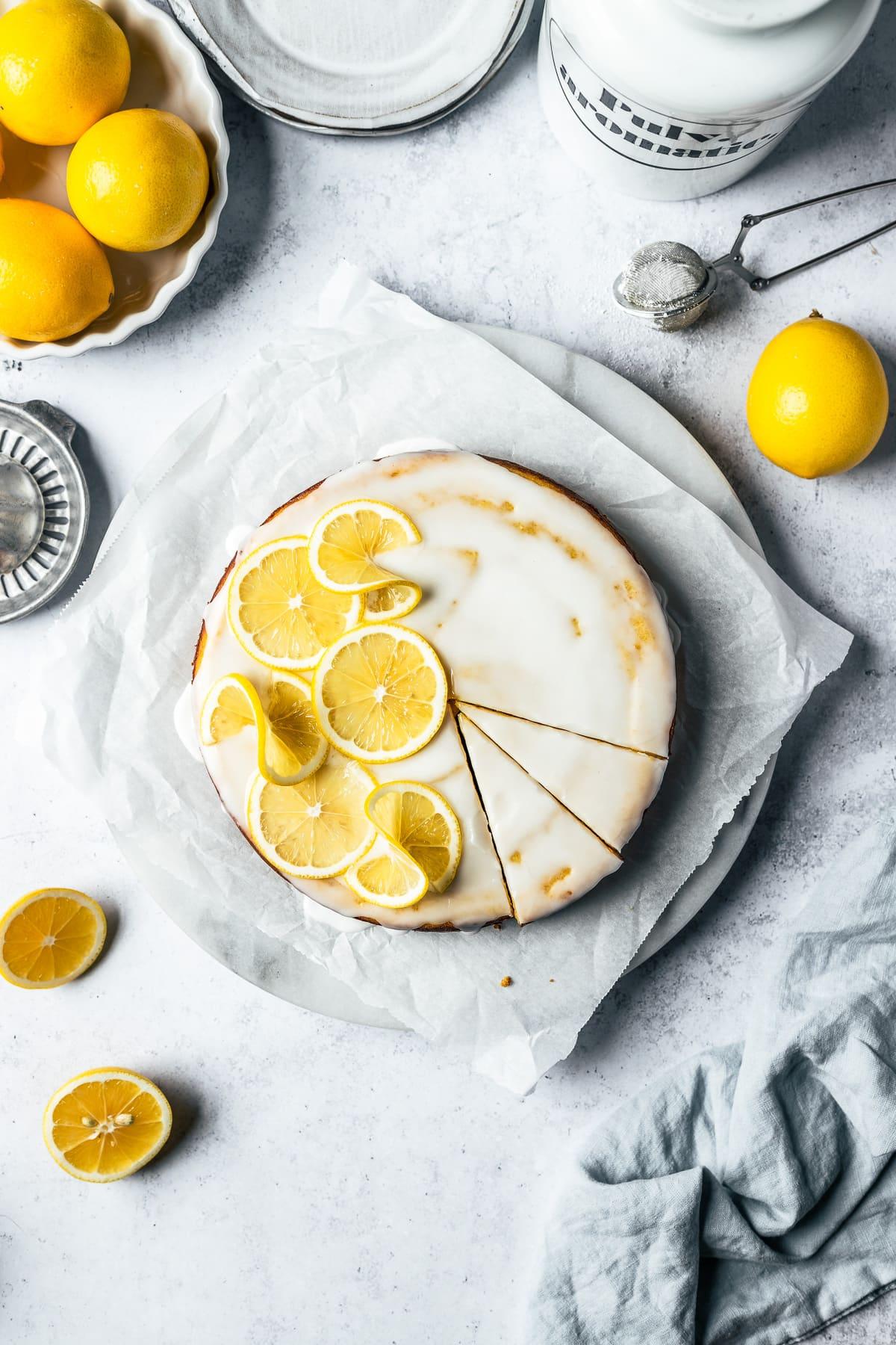 A whole lemon almond cake, decorated with lemon slices and almonds