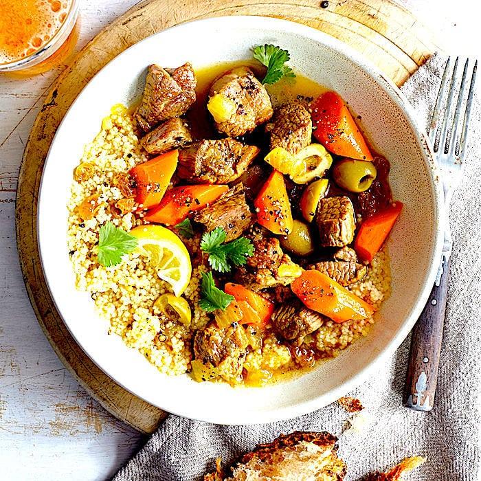Overhead shot of a beautifully plated lamb tagine with garnishes