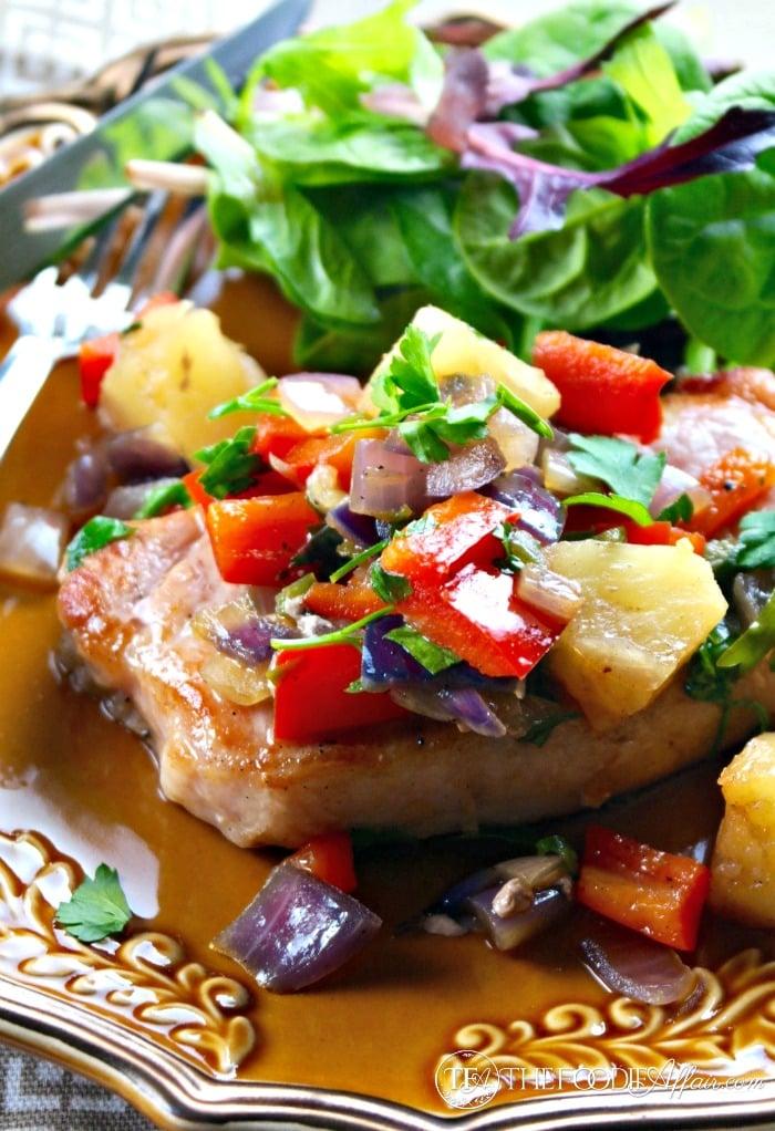 Spicy pork and pineapple roti on a plate with vibrant garnishes