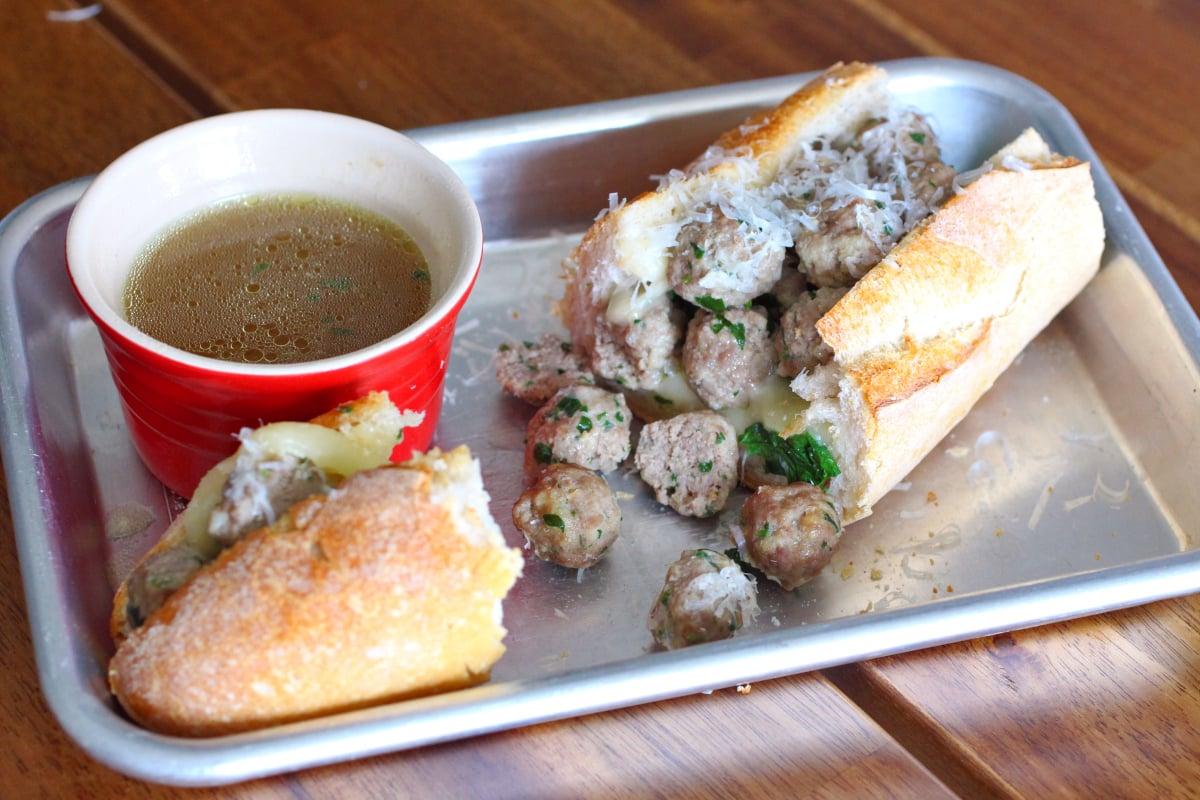A rustic kitchen scene with the Italian Wedding Soup Sandwich being enjoyed