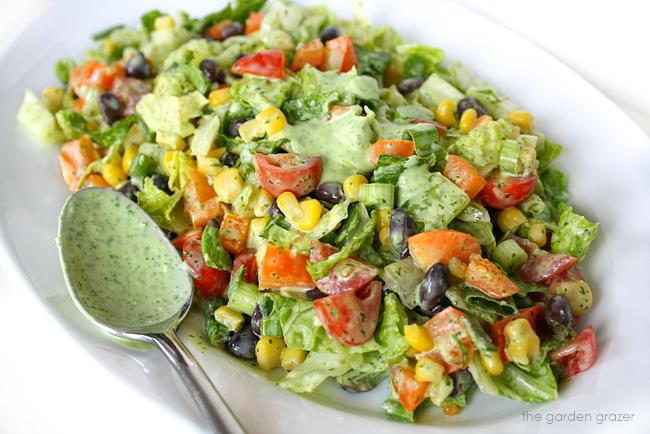 a person tossing the salad with lime dressing