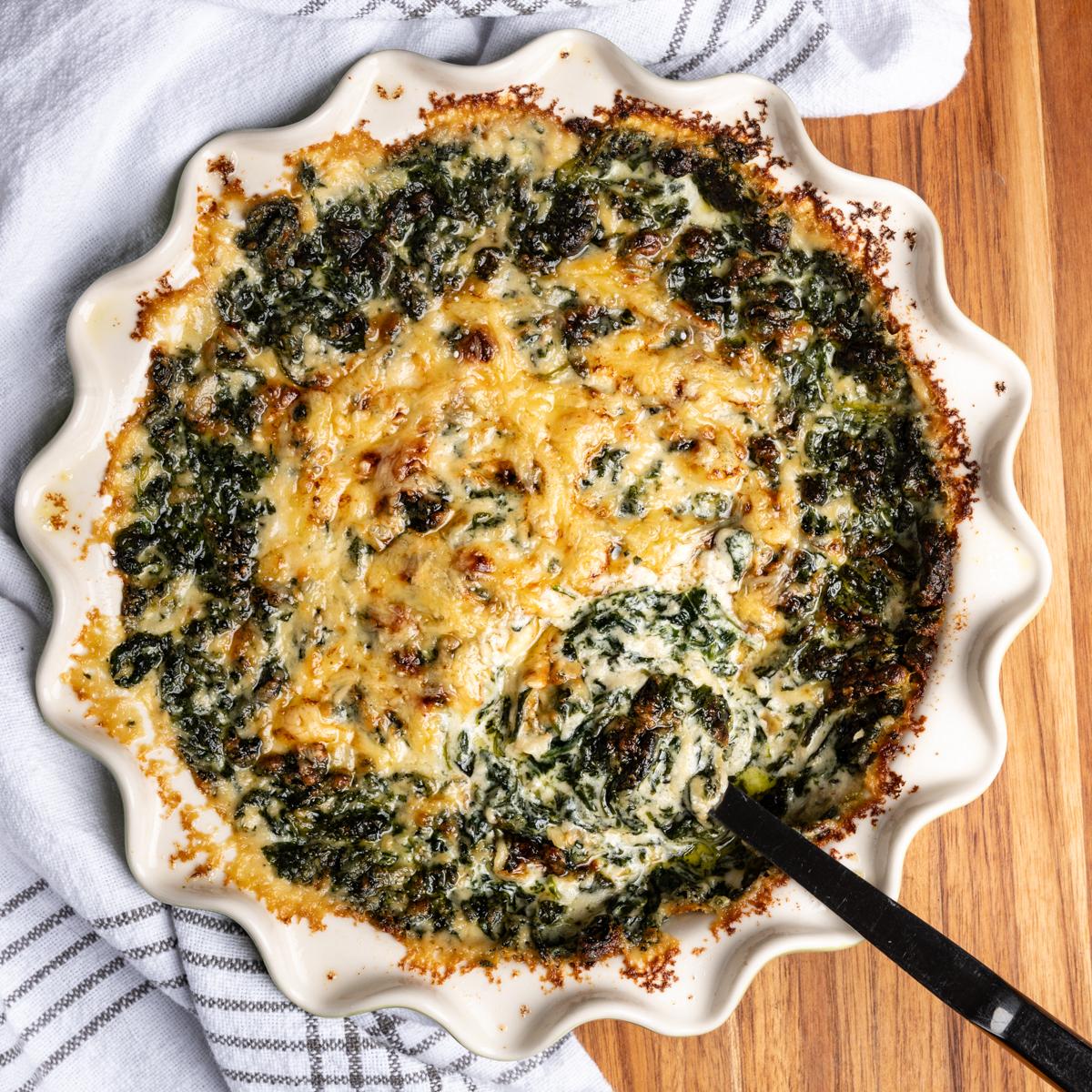 Ingredients for creamed spinach on a rustic wooden table