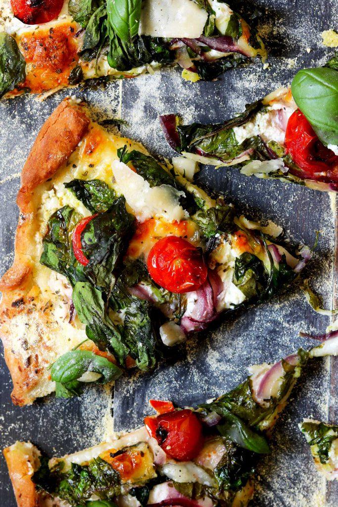 A delicious spinach and ricotta curry pizza with warm lighting