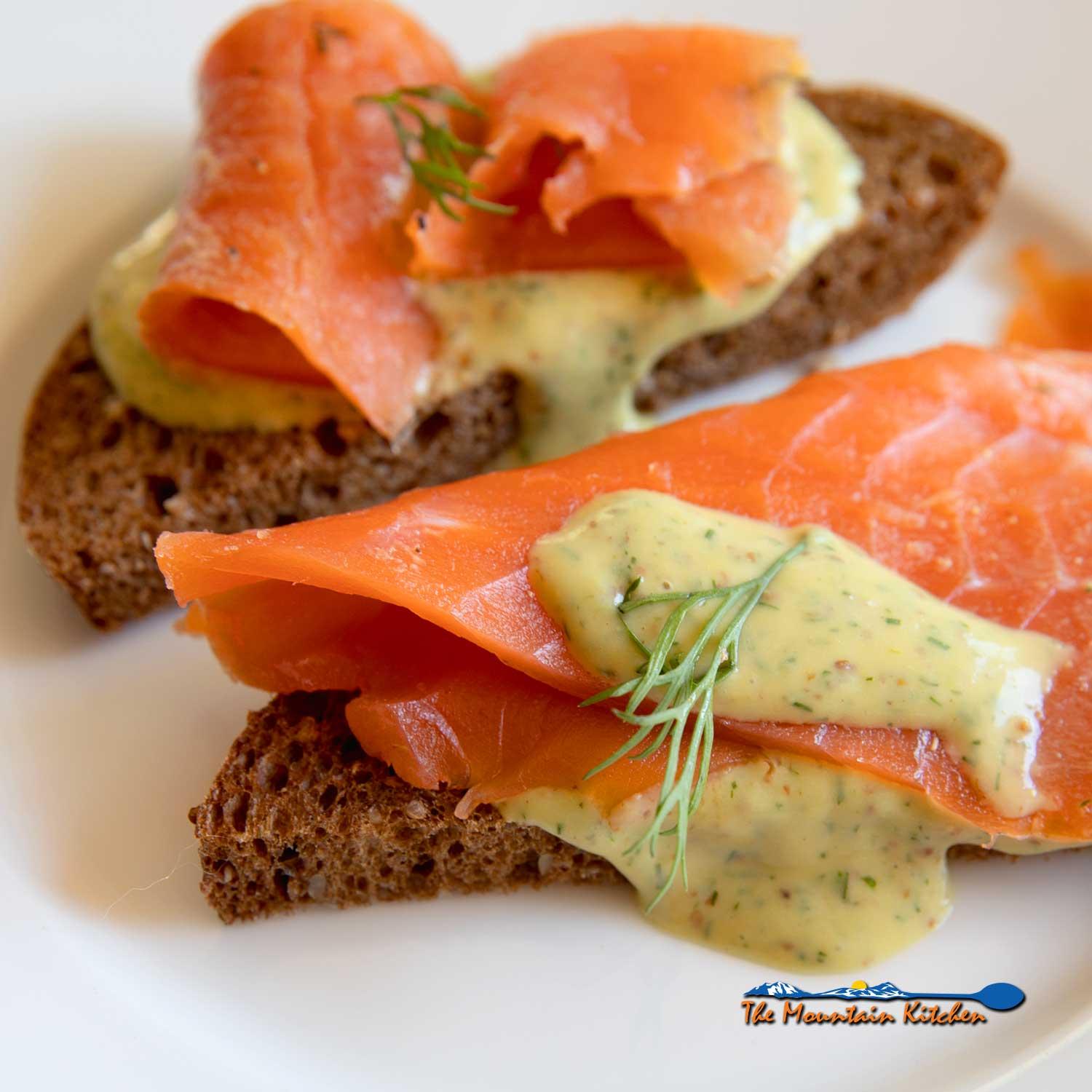 Chili flake gravlax sliced thinly and served on rye bread with cream cheese and dill