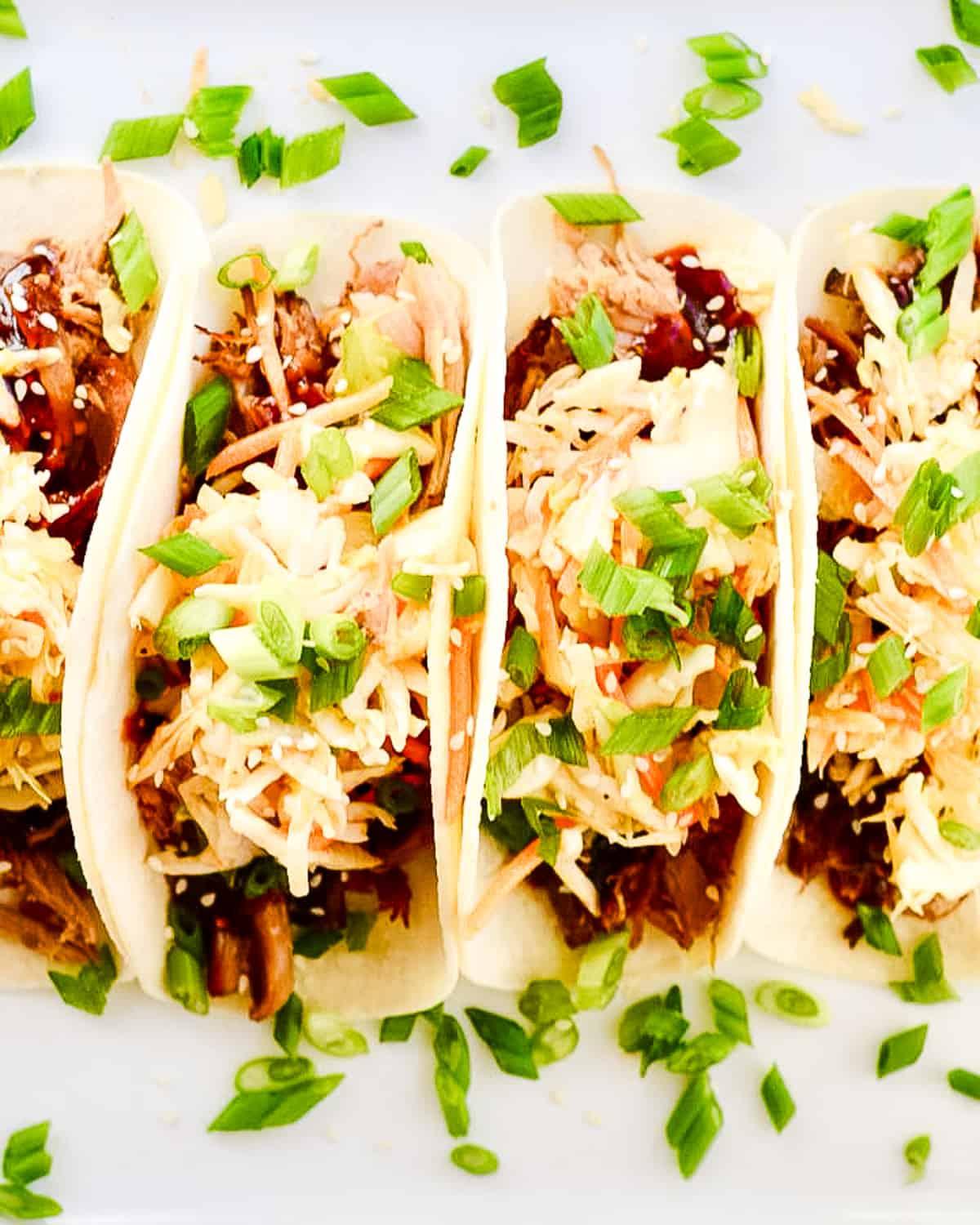 A platter of Korean BBQ & Kimchi Tacos surrounded by bowls of toppings
