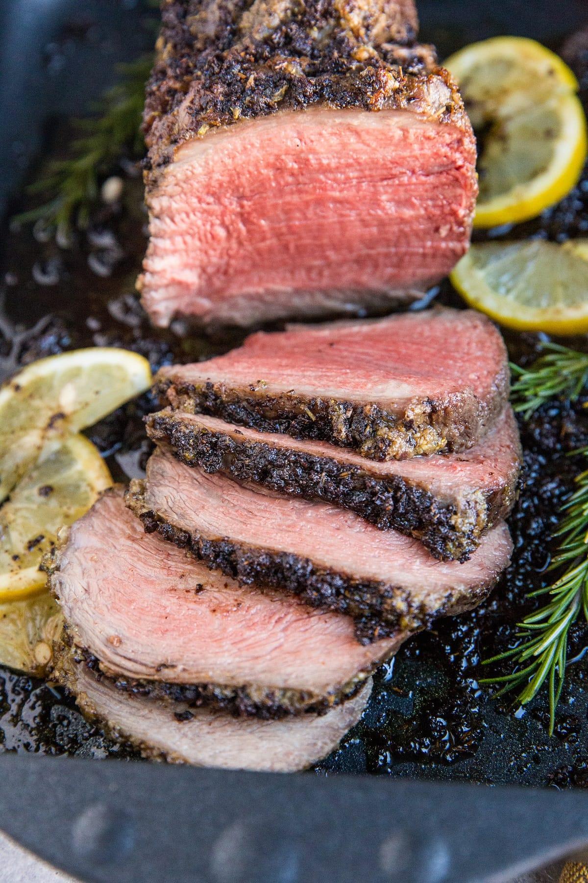 close-up shot of raw beef roast generously coated with garlic herb butter mixture