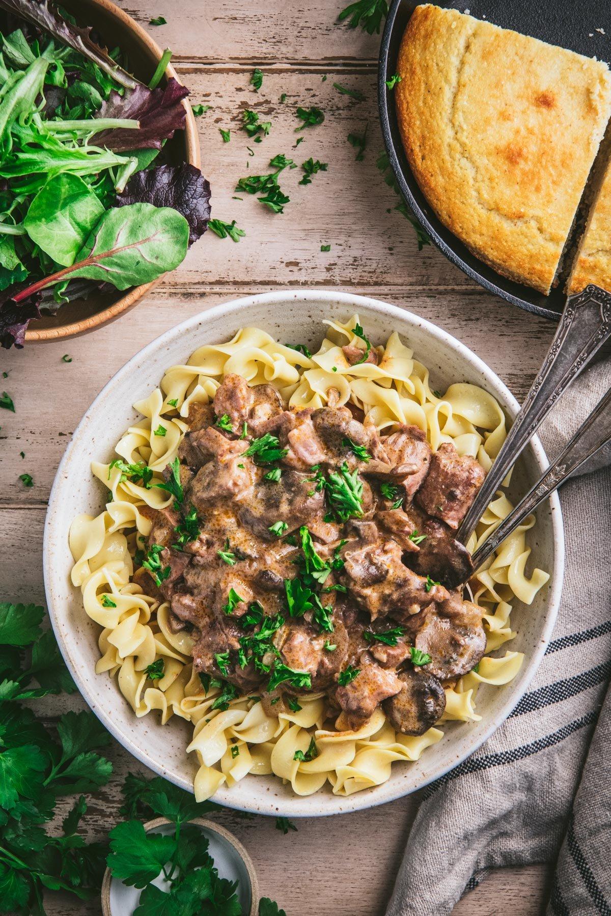 Overhead shot of a table set for a family dinner with a Beef Stroganoff Casserole at the center