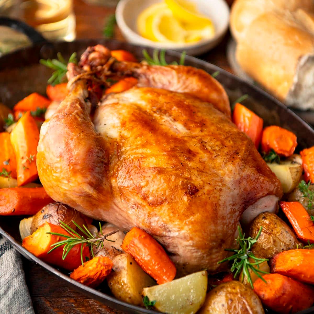 Close-up shot of a juicy roasted chicken with colorful vegetables