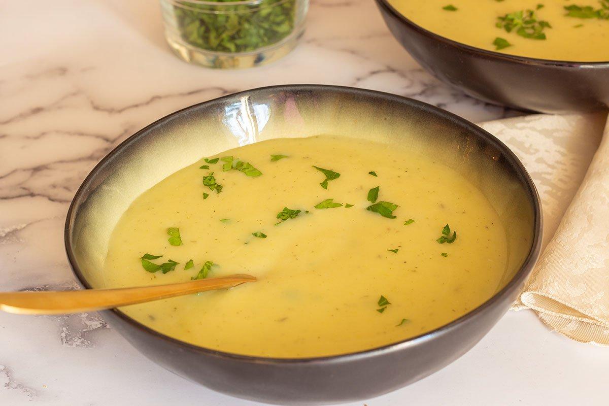 Close-up of a bowl of potato and leek soup with a spoon