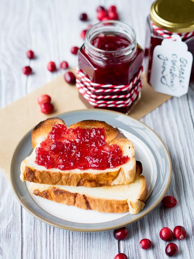 Jar of lingonberry jam and orange marmalade with toast