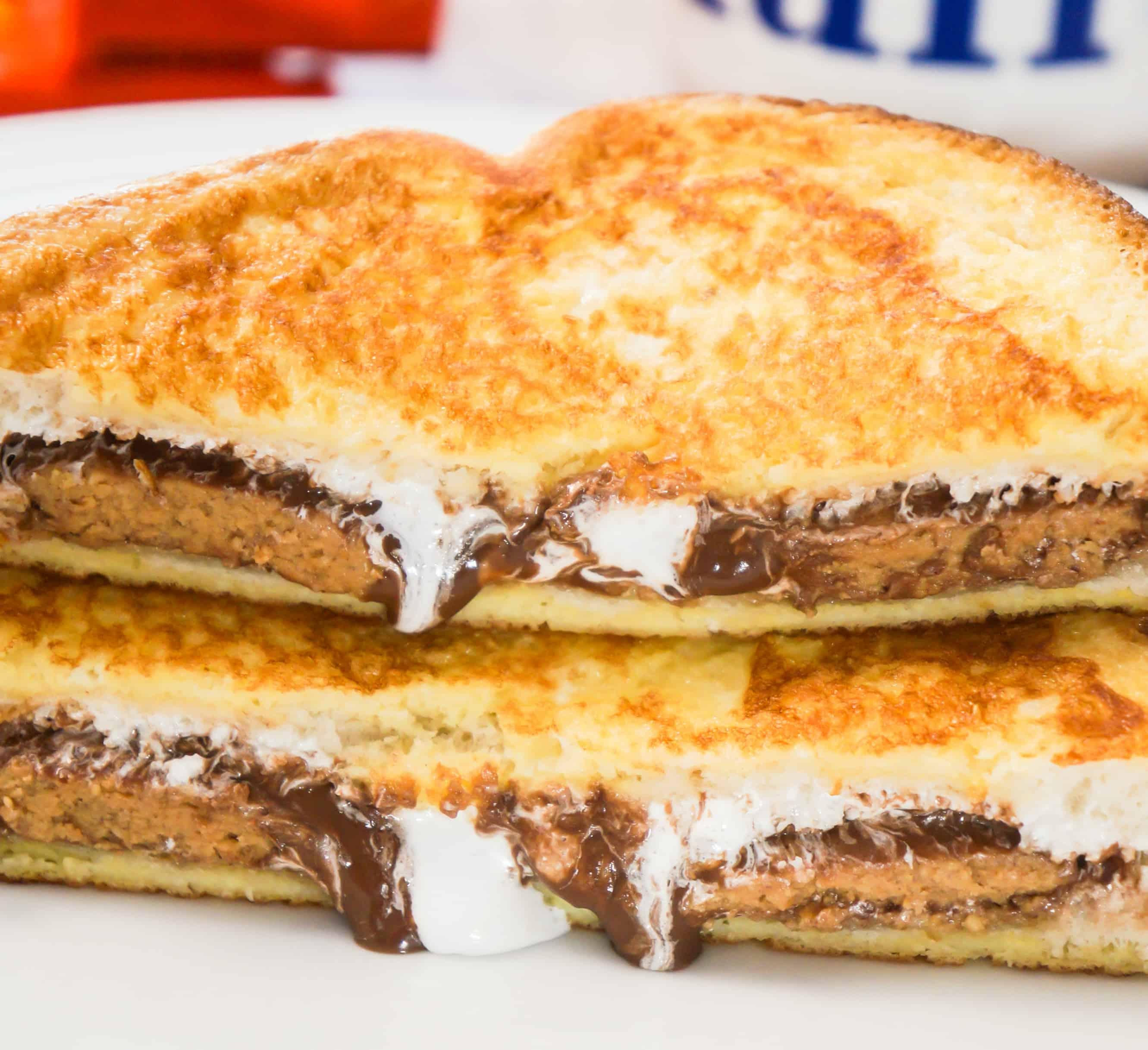 Close-up shot of golden brown Peanut Butter Cup French Toast, drizzled with syrup, with peanut butter cups on the side