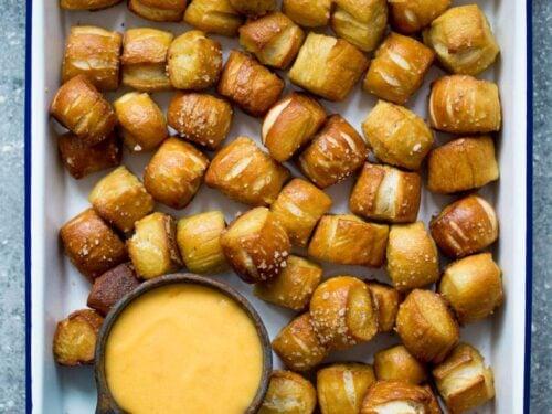 Close up shot of a half-eaten bag of pretzels and a jar of pizza sauce