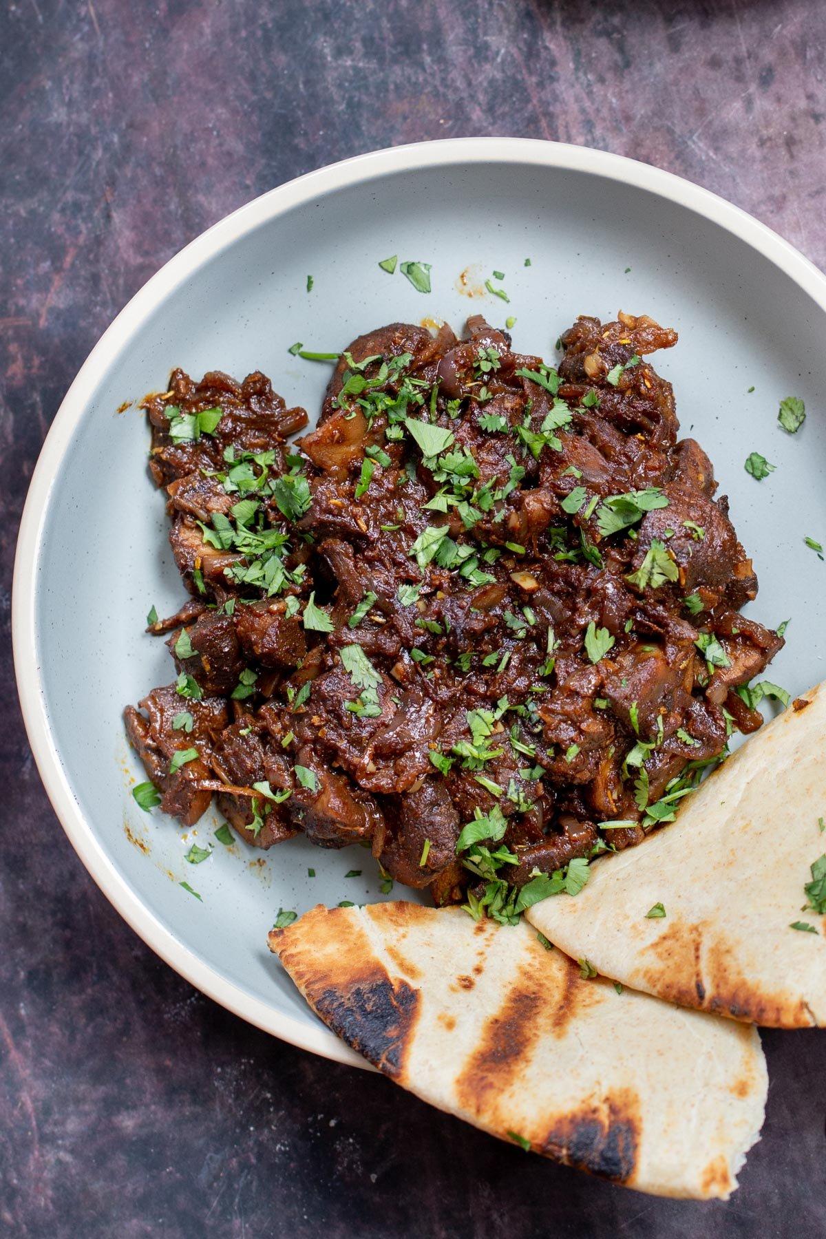Close-up shot of injera with mushrooms and onions