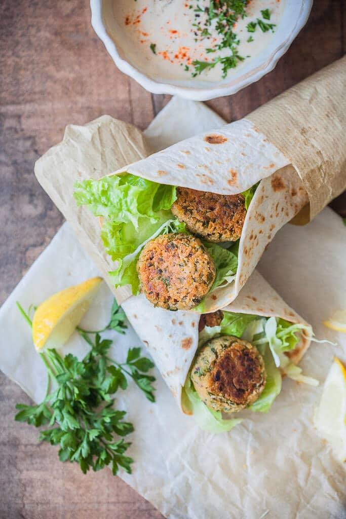 Close up shot of a plate of falafel with lemon tahini dressing
